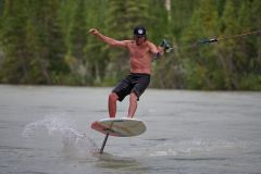 Todd Rice foil surfing (foil boarding) during high flow spring runoff in the Bow River, Canmore, Alberta, Canada.