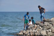 Mexican boys fishing in Lake Chapala, from the Malecon, Jocotopec, Jalisco, Mexico