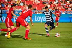 Jul 26, 2014; Toronto, Ontario, CAN; Sporting Kansas forward Dom Dwyer (14) tries a shot past Toronto FC defenders Nick Hagglund (17) and Bradley Orr (16) in first half of the game at BMO Field. Mandatory Credit: Peter Llewellyn-USA TODAY Sports