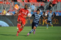 Jul 26, 2014; Toronto, Ontario, CAN; Toronto FC mid-fielder Collen Warner (26) gets past Sporting Kansas mid-fielder Mikey Lopez (12) in first half of game at BMO Field. Mandatory Credit: Peter Llewellyn-USA TODAY Sports