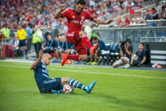 Jul 26, 2014; Toronto, Ontario, CAN; Toronto FC forward Gilberto (9) jumps over the leg of Sporting KC mid-fielder Aurelian Collin( 78) in second half at BMO Field - Sporting KC beat Toronto FC 2 - 1 Mandatory Credit: Peter Llewellyn-USA TODAY Sports
