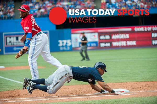 Jul 1, 2014; Toronto, Ontario, CAN; Milwaukee Brewers Left Field Khris Davis dives to make first base watched by Blue Jays First Baseman Edwin Encarcion Milwaukee Brewers and Toronto Blue Jays at Rogers Centre. Mandatory Credit: Peter Llewellyn-USA TODAY Sports