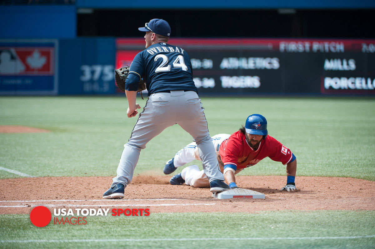 Jul 1, 2014; Toronto, Ontario, CAN; Toronto Blue Jays Darin Mastroianni (33)  dives back to first base while Brewers first baseman Lyle Overbay (24) attempts a tag at Milwaukee Brewers v Toronto Blue Jays at Rogers Centre - Blue Jays won 4 - 1. Mandatory Credit: Peter Llewellyn-USA TODAY Sports