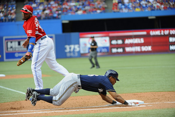 Jul 1, 2014; Toronto, Ontario, CAN; Milwaukee Brewers Left Field Khris Davis dives to make first base watched by Blue Jays First Baseman Edwin Encarcion Milwaukee Brewers and Toronto Blue Jays at Rogers Centre. Mandatory Credit: Peter Llewellyn-USA TODAY Sports